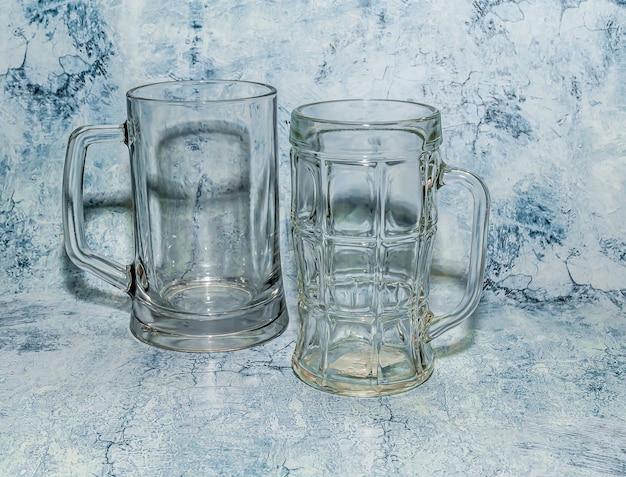 Glass beer mugs on a blue background closeup