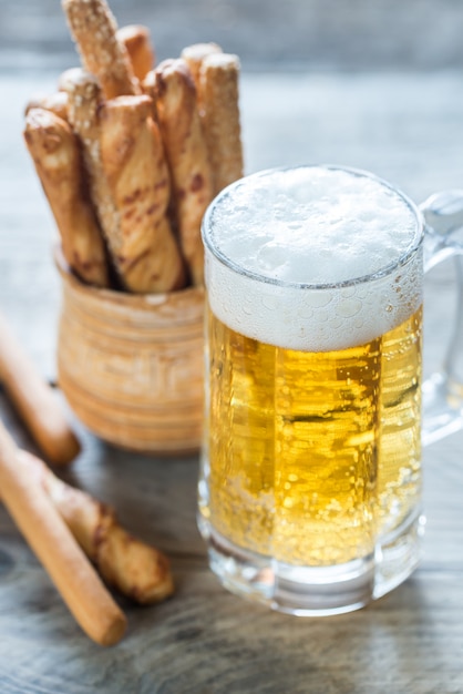 Glass of beer with breadsticks