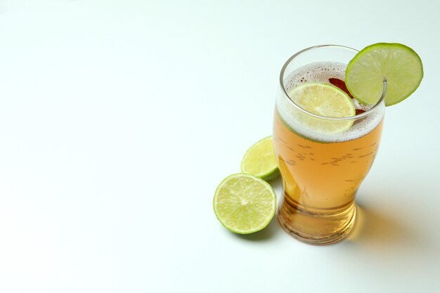 Glass of beer with lime on white