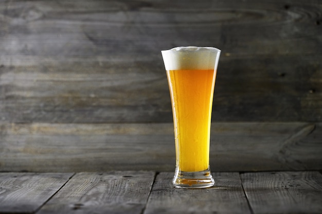 Glass beer on wood background.