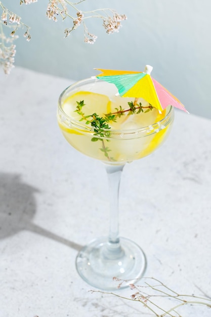 Glass of bees knees gin cocktail with lemon and thyme