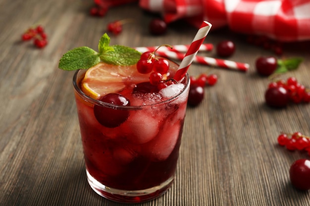 glass of berry juice on wooden table closeup