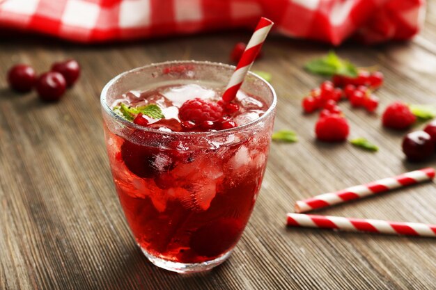 glass of berry juice on wooden table closeup