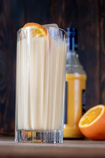 Glass of Bessie and Jessie Cocktail garnished with orange slice wheel