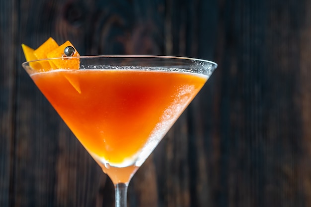 Glass of Blood And Sand Cocktail in martini glass garnished with orange peel