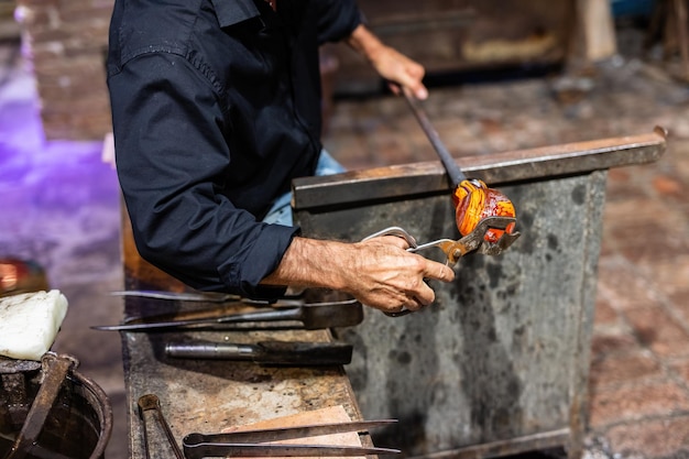 Glass blower at work in workshop in Murano Italy making handmade glassware