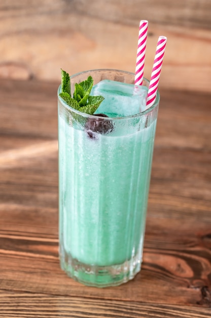 Glass of Blue Hawaiian cocktail on wooden table