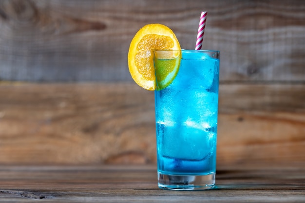 Glass of Blue Lagoon cocktail garnished with an orange slice