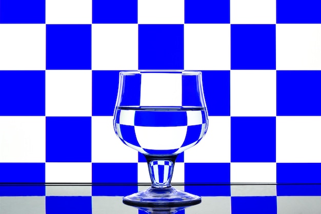 Photo glass on a blue and white background with a reflection on the table.