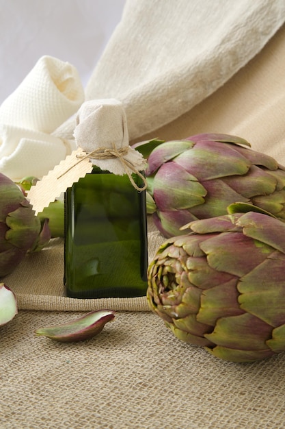 A glass bottle of artichoke oil on a sackcloth