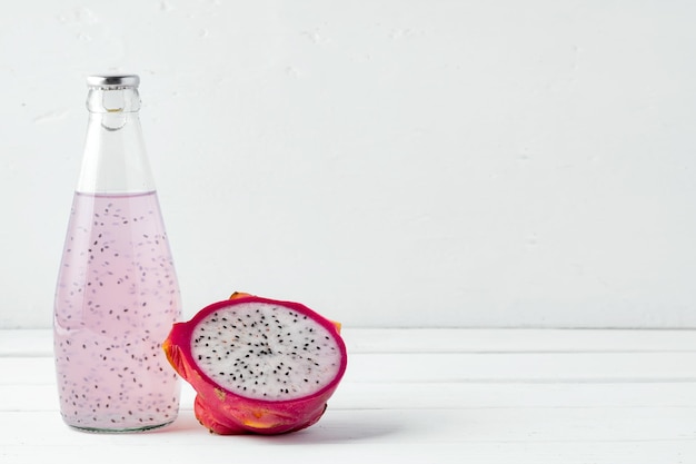 Bottiglia di vetro della bevanda alla frutta del drago su fondo bianco
