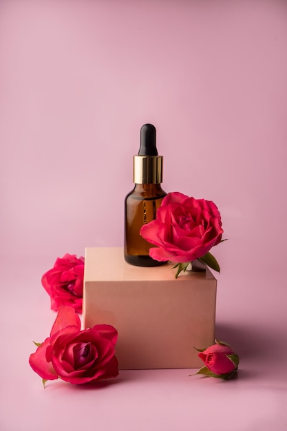 Glass bottle for drops and liquid and oils Advertising of a cosmetology product Roses Pink water