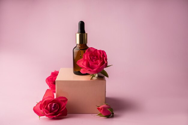 Glass bottle for drops and liquid and oils Advertising of a cosmetology product Roses Pink water