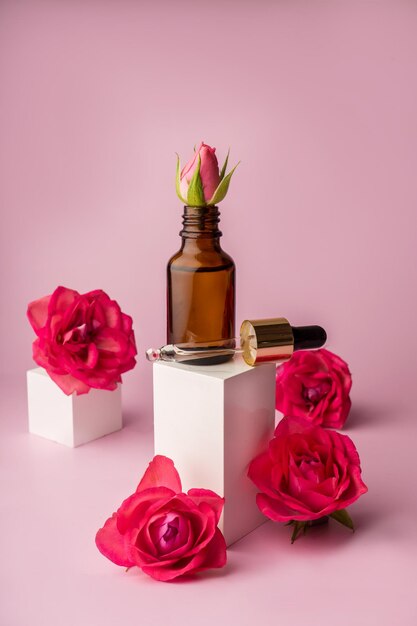 Glass bottle for drops and liquid and oils Advertising of a cosmetology product Roses Pink water