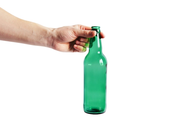 Photo glass bottle in hand on a white wall. empty bottle. green bottle on a clean wall