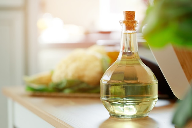 Стеклянная бутылка масла на кухонном столе