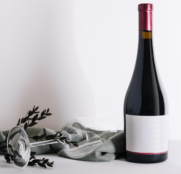 Glass and bottle of wine on light background