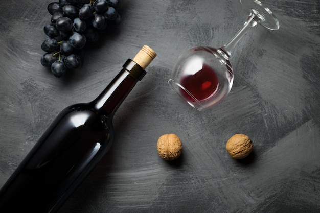 Glass bottle of wine with corks on wooden table background