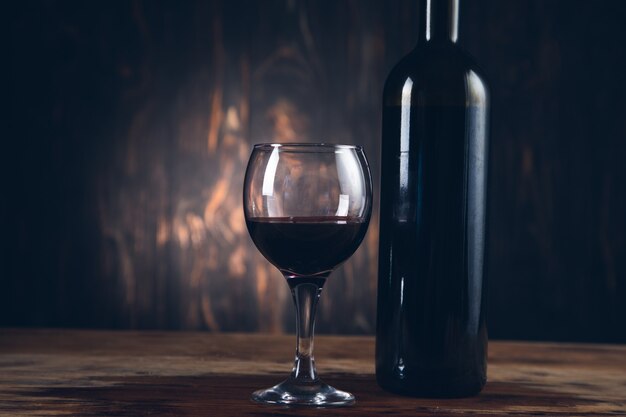 Glass and bottle of wine on the wooden background