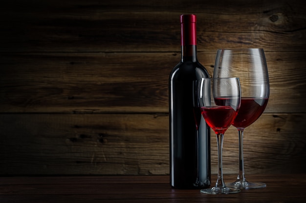 Glass and bottle of wine on a wooden background