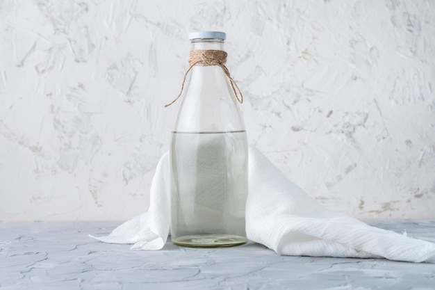 Glass bottle with absolutely clean distilled water isolated on grunge surfaces