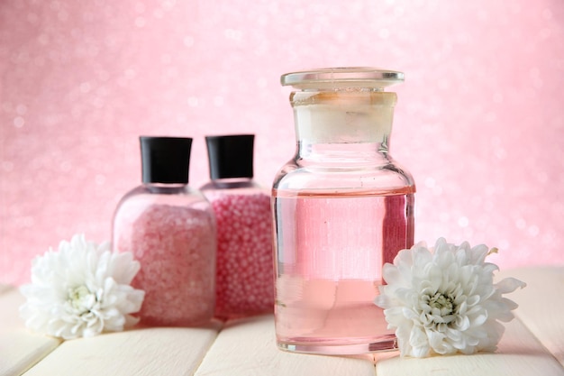 Glass bottle with color essence on pink background