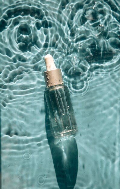 glass bottle with face serum on water drops