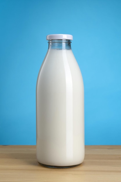 青い背景に新鮮なミルクとガラス瓶