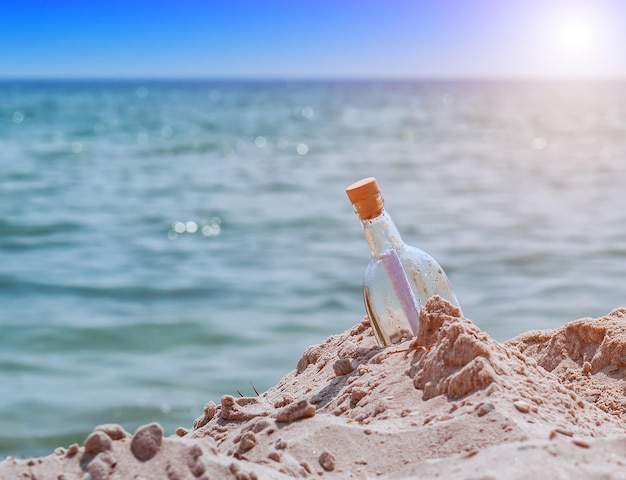 Glass bottle with letter on the beach