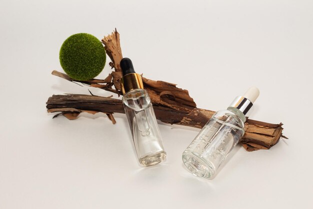 Photo glass bottle with a pipette jar with serum transparent gel and green moss balls on a white background natural moisturizing serum with hyaluronic acid body and face care cosmetics concept