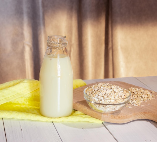 Glass bottle with vegetable oat milk and oat flakes lactose-free milk vegetarianism