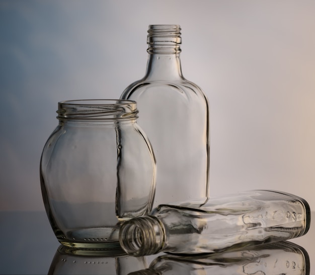 Glass bottles and jars on a colored background