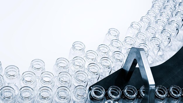 Glass bottles in production in the tray of an automatic liquid dispenser, a line for filling medicines against bacteria and viruses, antibiotics and vaccines.