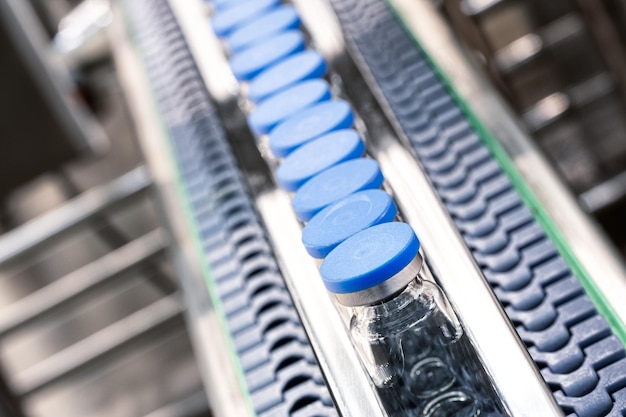 Glass bottles in production in the tray of an automatic liquid dispenser, a line for filling medicines against bacteria and viruses, antibiotics and vaccines.