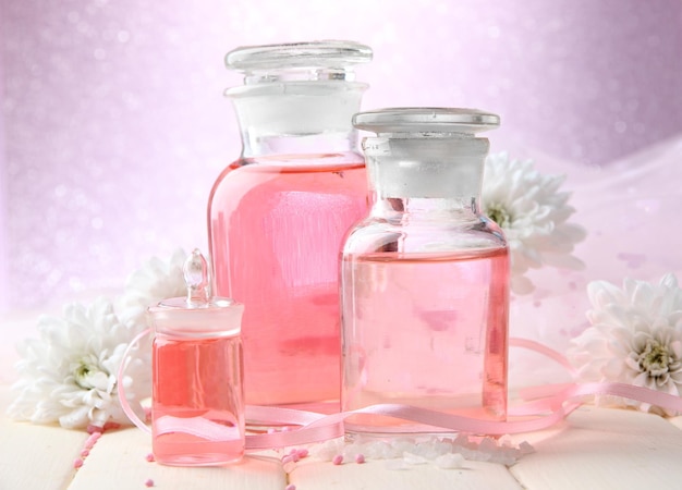 Glass bottles with color essence on pink background