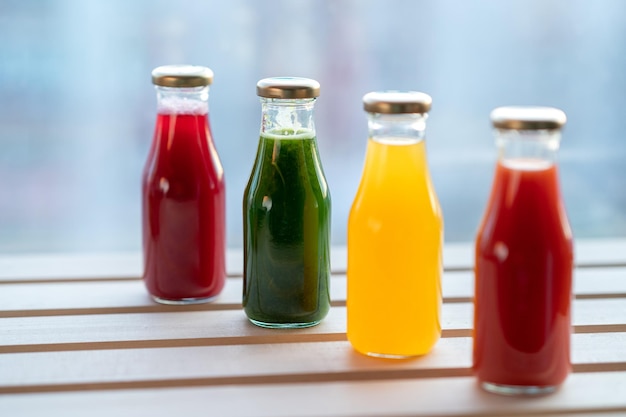 glass bottles with colorful fresh juice fruit and vegetable smoothies