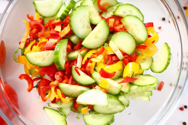 Insalata di verdure dell'ingrediente della tenuta della ciotola di vetro