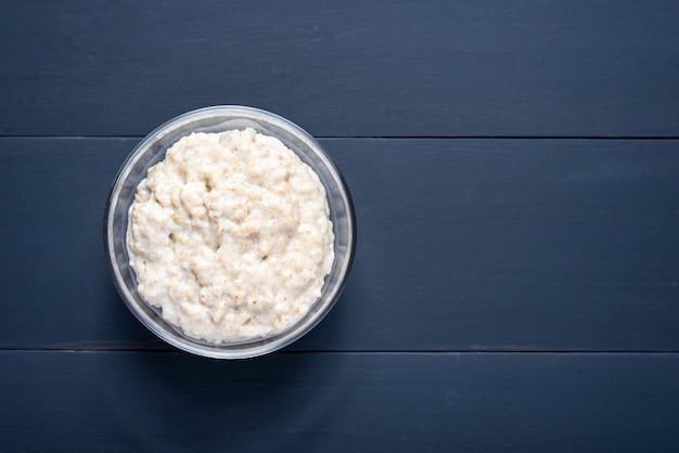 glass bowl of oatmeal on grey wood