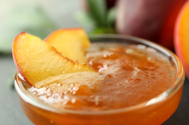 glass bowl of peach jam, close up and selective focus