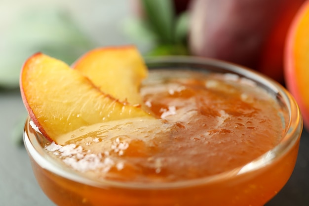 Glass bowl of peach jam, close up and selective focus