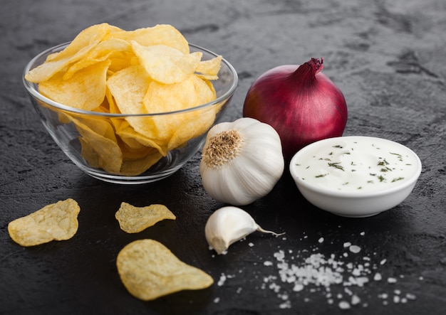 Glass bowl plate with potato crisps chips with onion flavour with garlic and salt