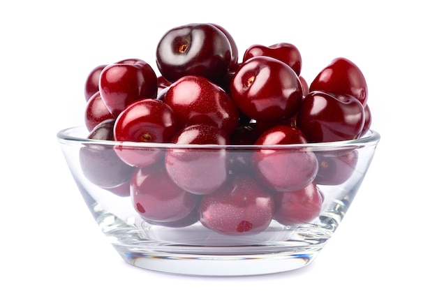 Glass bowl of sweet cherry fruits isolated on white