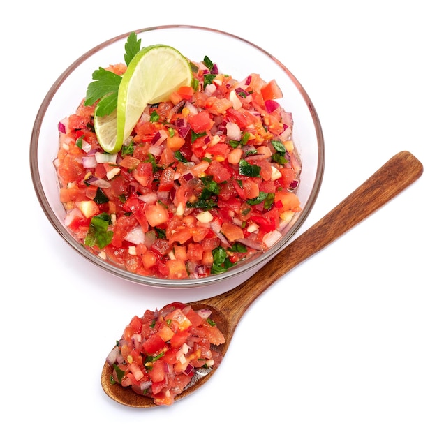 Glass bowl of tomato salsa dip with Tortilla chips isolated on white background