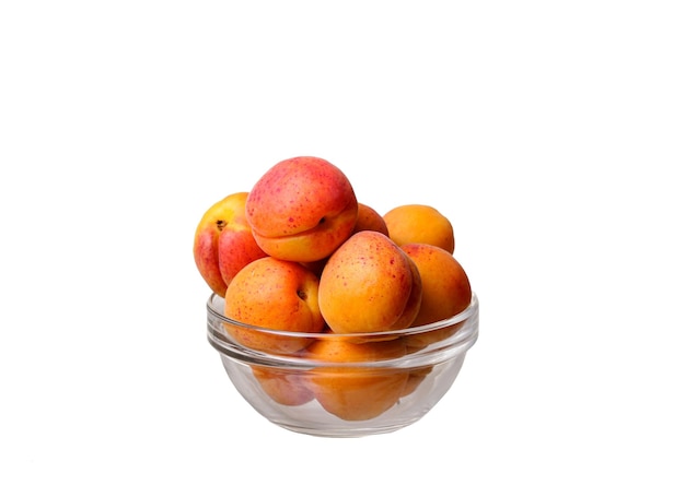 Стеклянная чаша с абрикосами на белом фоне