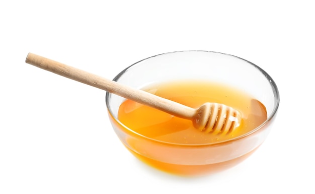 Glass bowl with dipper and delicious honey on white background