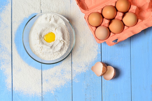 Glass bowl with flour and an egg