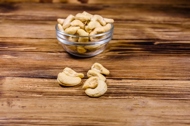 Glass bowl with raw cashew nuts on a wooden table