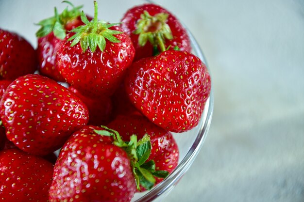 Foto ciotola di vetro con fragole mature