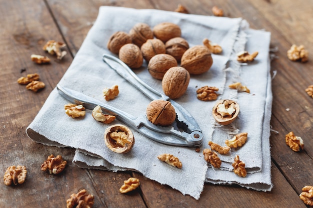 Glass bowl with walnuts on rustic homespun napkin. Healthy snack on old wood