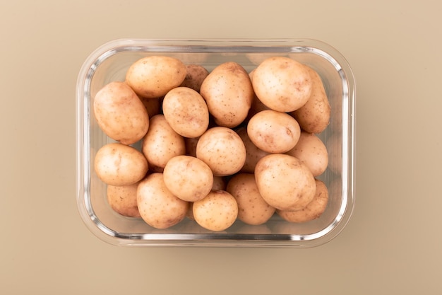 Стеклянная коробка со свежим сырым картофелем Овощи в стеклянной таре Концепция хранения продуктов